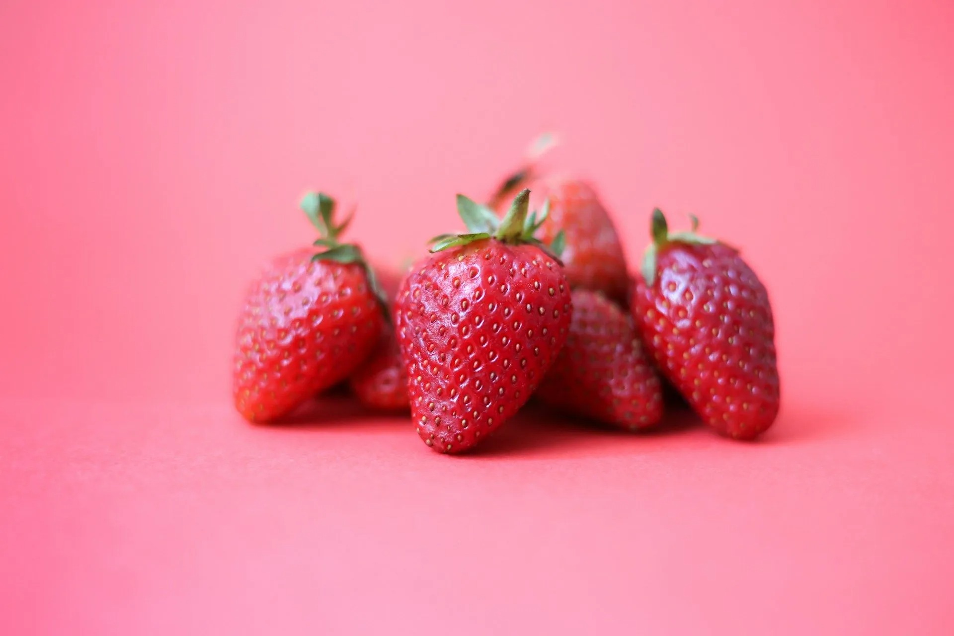 Fresh ripe strawberries on a pink background